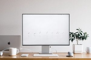 Bureau informatique avec Mac, clavier, souris et écran