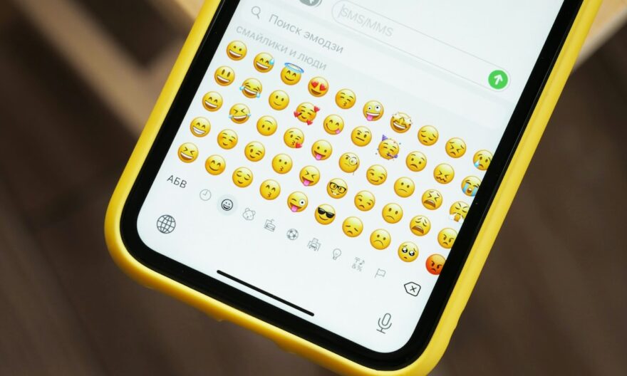 iPhone jaune affichant de nombreux emojis sur le clavier